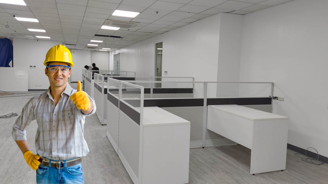  This image shows a contractor giving a thumbs-up in an office space that is being set up with new cubicles. It highlights the progress of the office construction and the contractor's approval of the work being done.