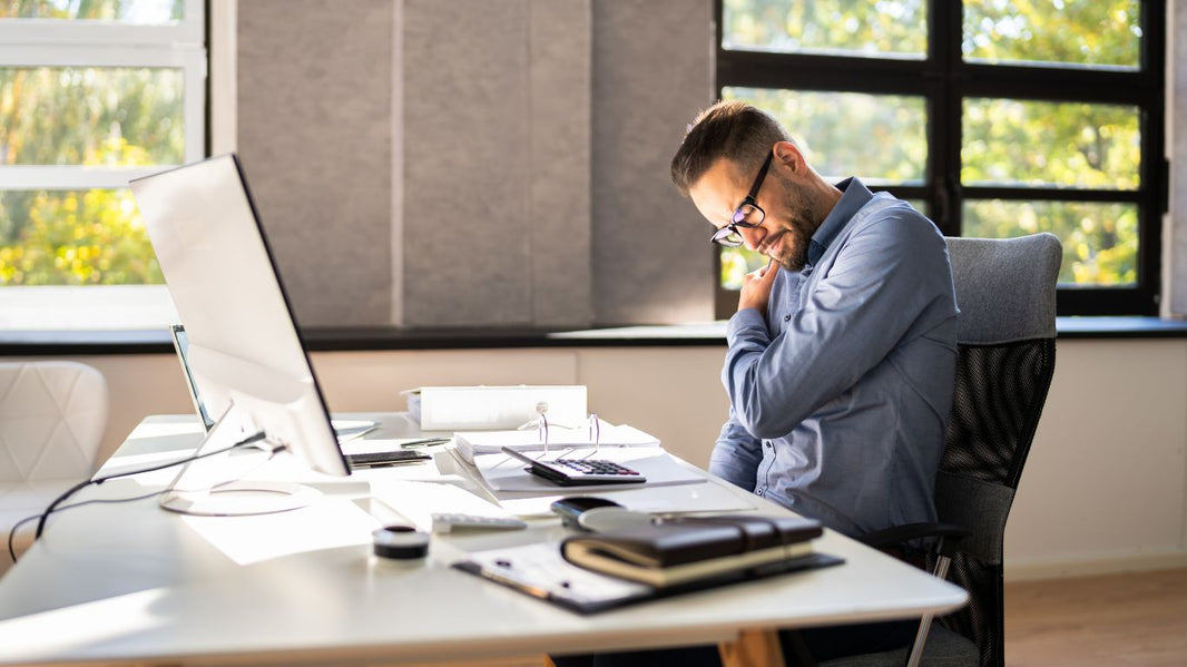 A man sitting on an office chair with no proper back and head support.